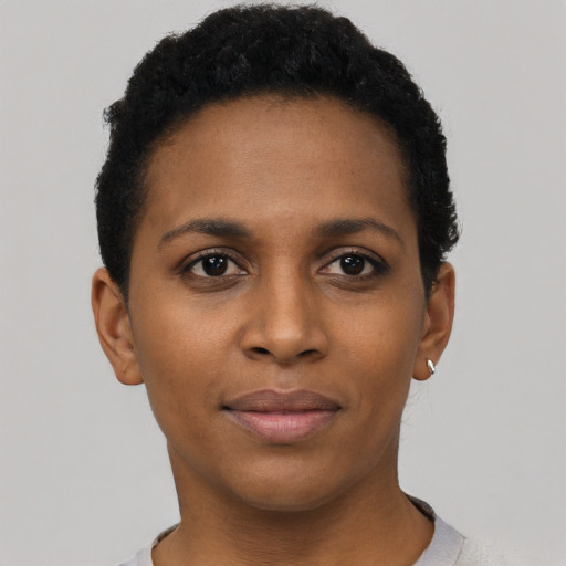 Joyful black young-adult female with short  black hair and brown eyes