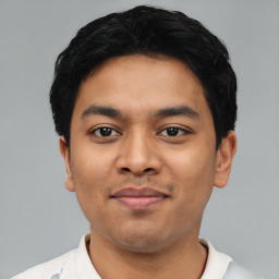 Joyful latino young-adult male with short  black hair and brown eyes