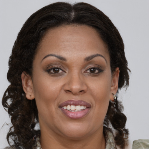 Joyful latino adult female with medium  brown hair and brown eyes