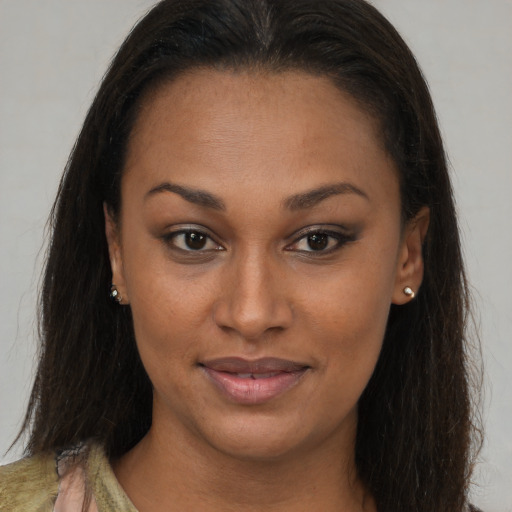 Joyful black young-adult female with long  brown hair and brown eyes