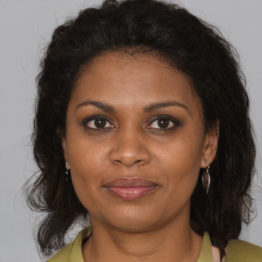 Joyful black adult female with long  brown hair and brown eyes