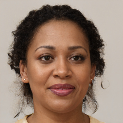 Joyful latino adult female with medium  brown hair and brown eyes