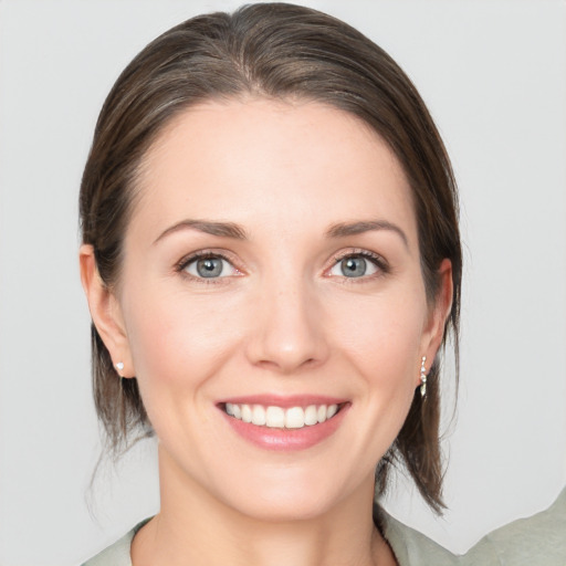 Joyful white young-adult female with medium  brown hair and grey eyes