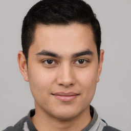 Joyful latino young-adult male with short  brown hair and brown eyes