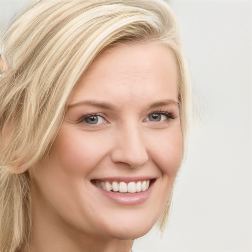 Joyful white young-adult female with long  blond hair and blue eyes