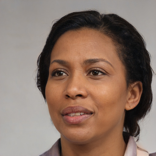 Joyful black adult female with medium  brown hair and brown eyes