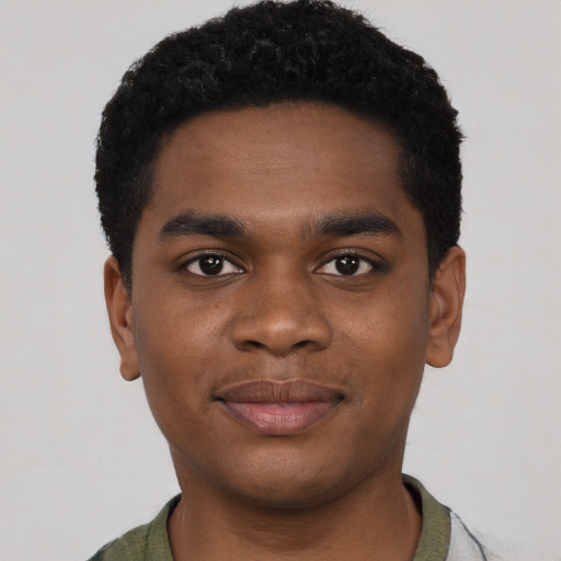 Joyful black young-adult male with short  black hair and brown eyes