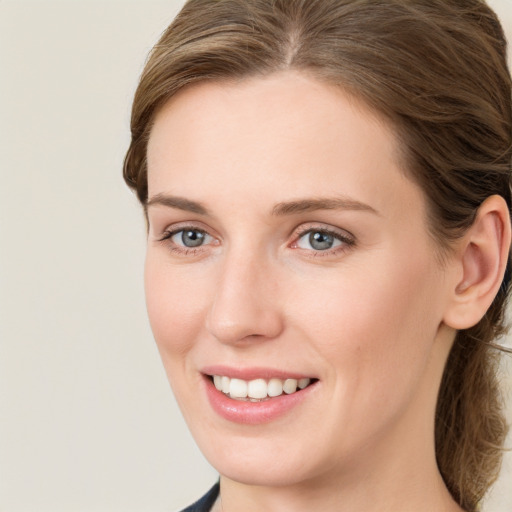 Joyful white young-adult female with long  brown hair and blue eyes