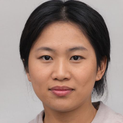 Joyful asian young-adult female with medium  black hair and brown eyes