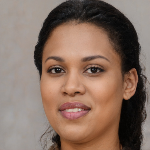 Joyful black young-adult female with long  brown hair and brown eyes