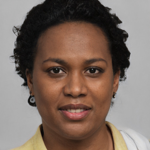 Joyful black young-adult female with short  brown hair and brown eyes