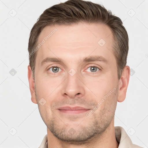 Joyful white young-adult male with short  brown hair and grey eyes