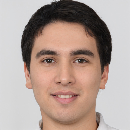 Joyful white young-adult male with short  black hair and brown eyes