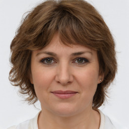 Joyful white young-adult female with medium  brown hair and green eyes