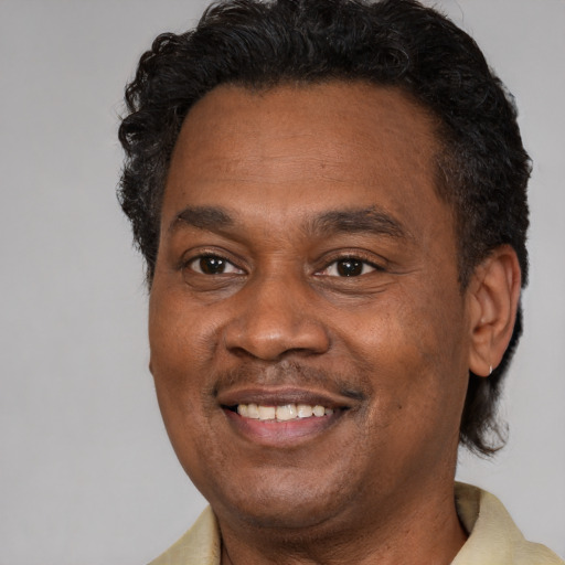 Joyful black adult male with short  brown hair and brown eyes