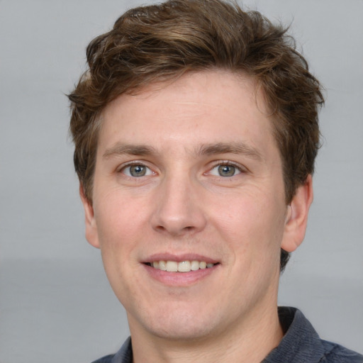 Joyful white adult male with short  brown hair and grey eyes