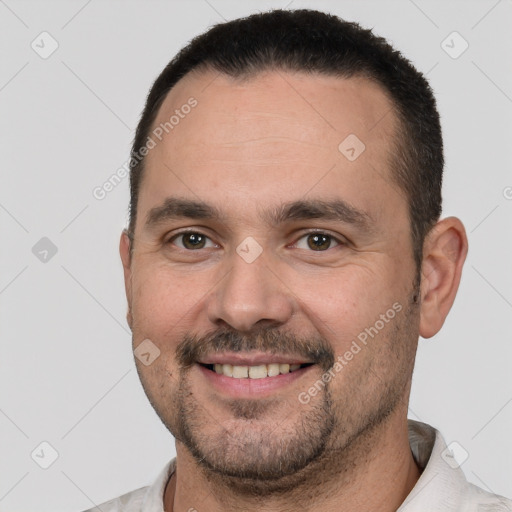 Joyful white adult male with short  black hair and brown eyes