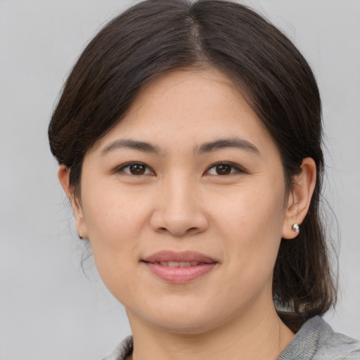 Joyful asian young-adult female with medium  brown hair and brown eyes