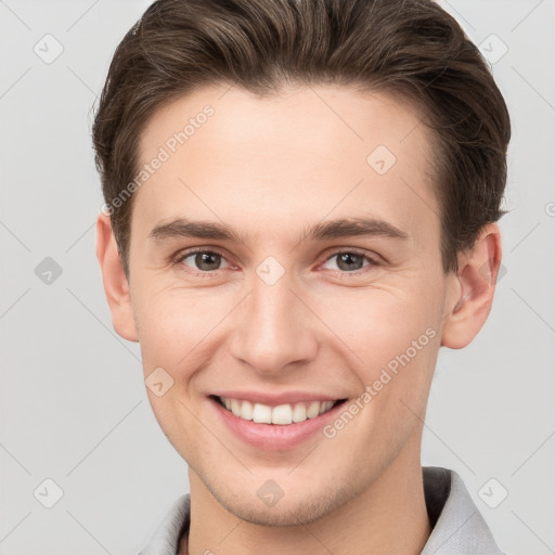 Joyful white young-adult male with short  brown hair and grey eyes