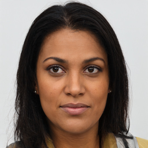 Joyful black young-adult female with long  brown hair and brown eyes