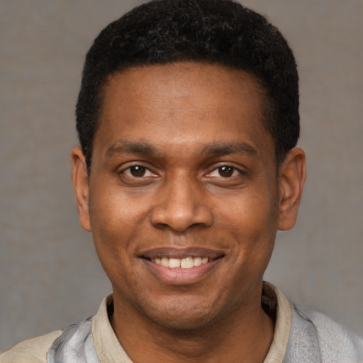 Joyful latino young-adult male with short  brown hair and brown eyes