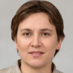 Joyful white adult female with medium  brown hair and grey eyes