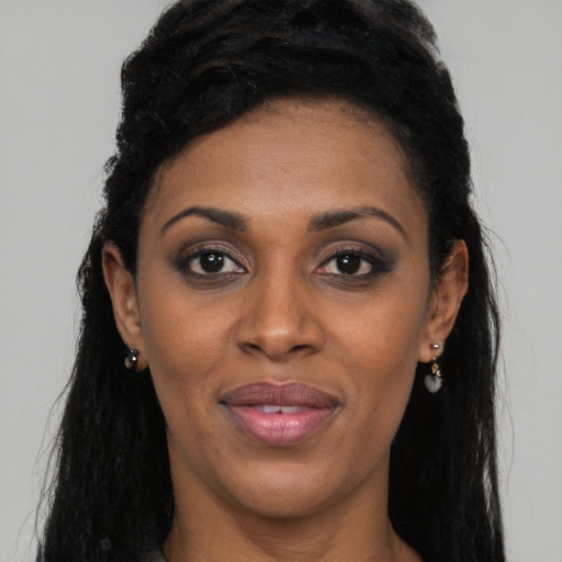 Joyful black young-adult female with long  black hair and brown eyes