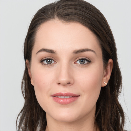 Joyful white young-adult female with long  brown hair and grey eyes