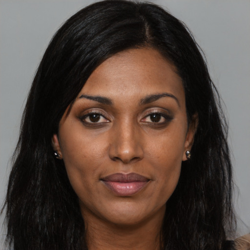 Joyful black young-adult female with long  black hair and brown eyes