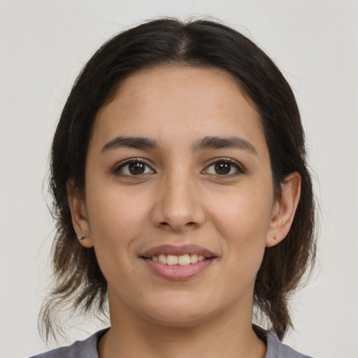 Joyful latino young-adult female with medium  brown hair and brown eyes