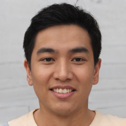 Joyful asian young-adult male with short  black hair and brown eyes