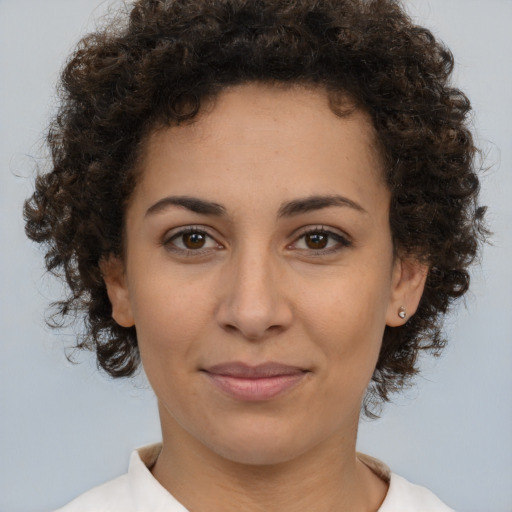 Joyful latino young-adult female with medium  brown hair and brown eyes