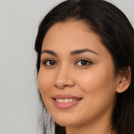 Joyful latino young-adult female with long  brown hair and brown eyes