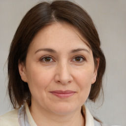 Joyful white adult female with medium  brown hair and brown eyes