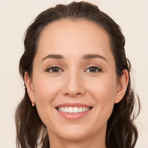 Joyful white young-adult female with long  brown hair and brown eyes