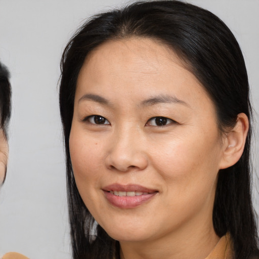 Joyful asian adult female with medium  brown hair and brown eyes