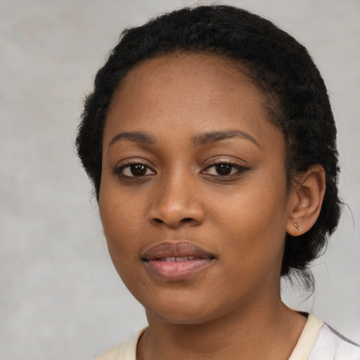Joyful black young-adult female with short  black hair and brown eyes