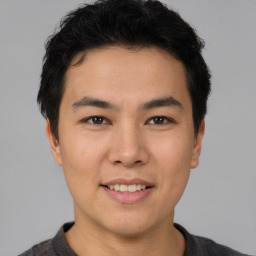 Joyful asian young-adult male with short  brown hair and brown eyes