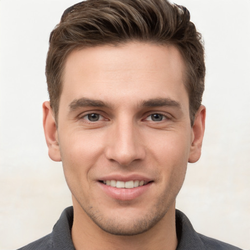 Joyful white young-adult male with short  brown hair and grey eyes