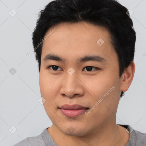 Joyful asian young-adult male with short  black hair and brown eyes