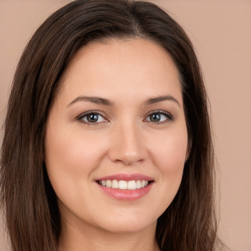 Joyful white young-adult female with long  brown hair and brown eyes