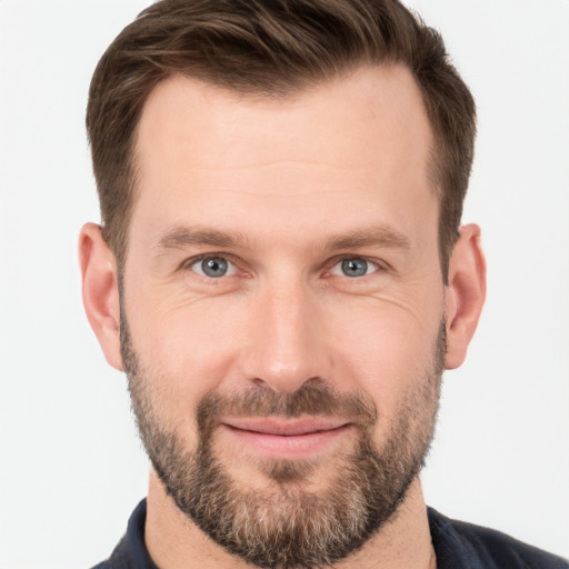 Joyful white young-adult male with short  brown hair and grey eyes