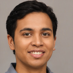 Joyful latino young-adult male with short  brown hair and brown eyes