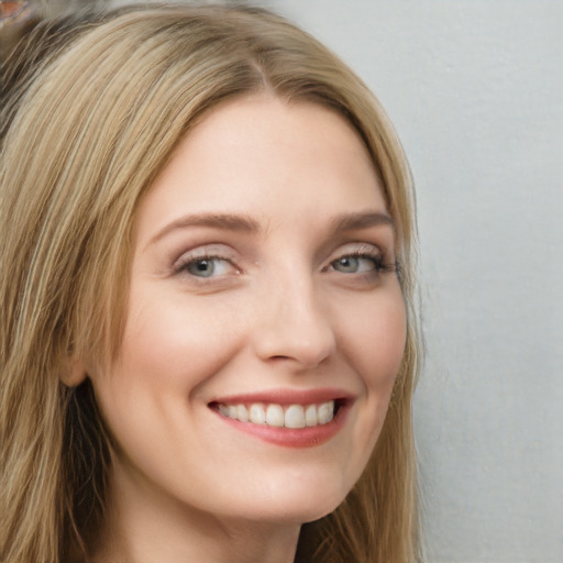 Joyful white young-adult female with long  brown hair and blue eyes