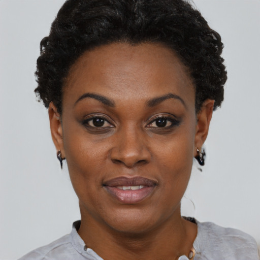 Joyful black young-adult female with short  black hair and brown eyes