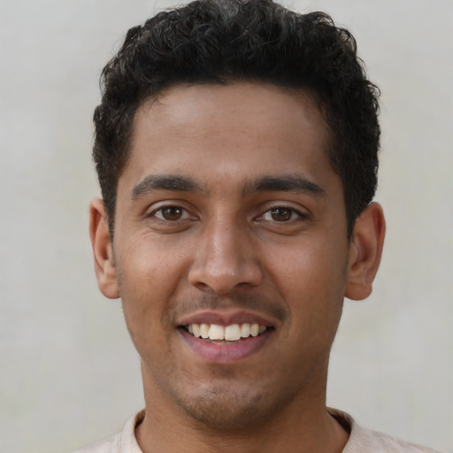 Joyful latino young-adult male with short  brown hair and brown eyes