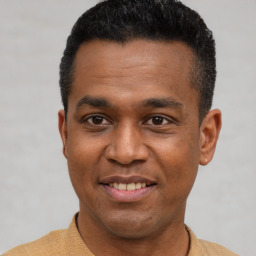 Joyful latino young-adult male with short  black hair and brown eyes