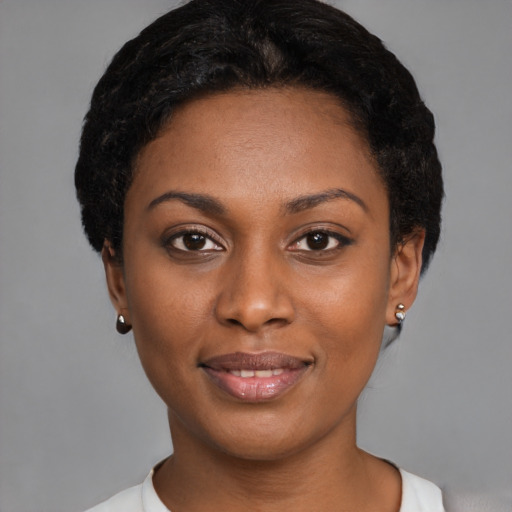 Joyful black young-adult female with short  black hair and brown eyes