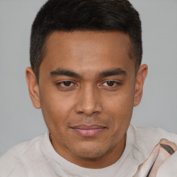 Joyful latino young-adult male with short  brown hair and brown eyes