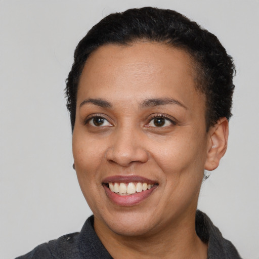 Joyful black adult female with short  black hair and brown eyes